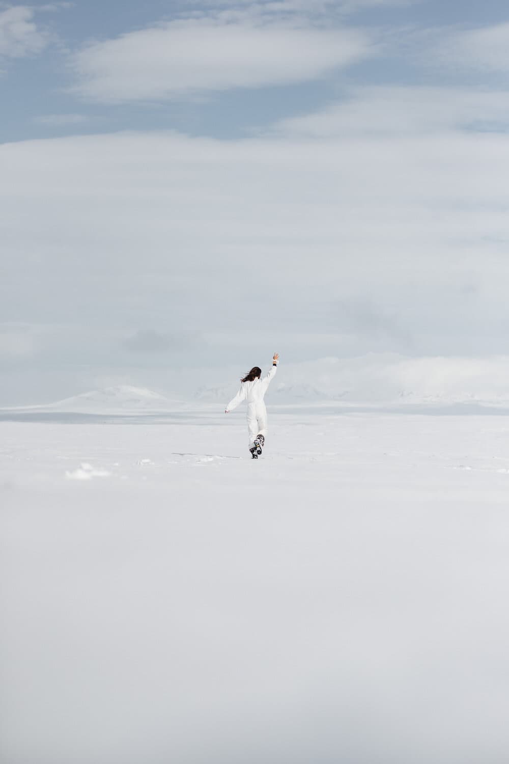Girl in white in the white snow seamlessly blending