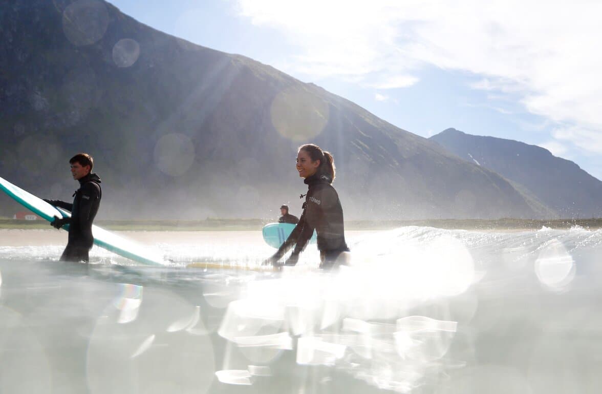 Group of friends surfing in the Arctic
