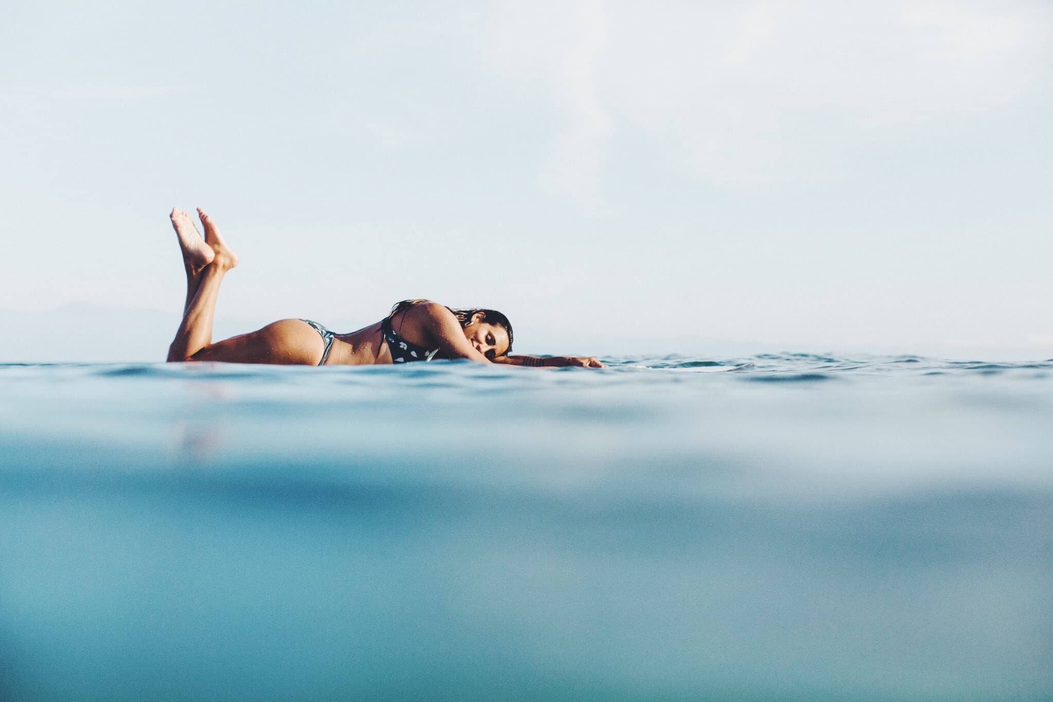 Girl surfing longboard waves in the Maldives