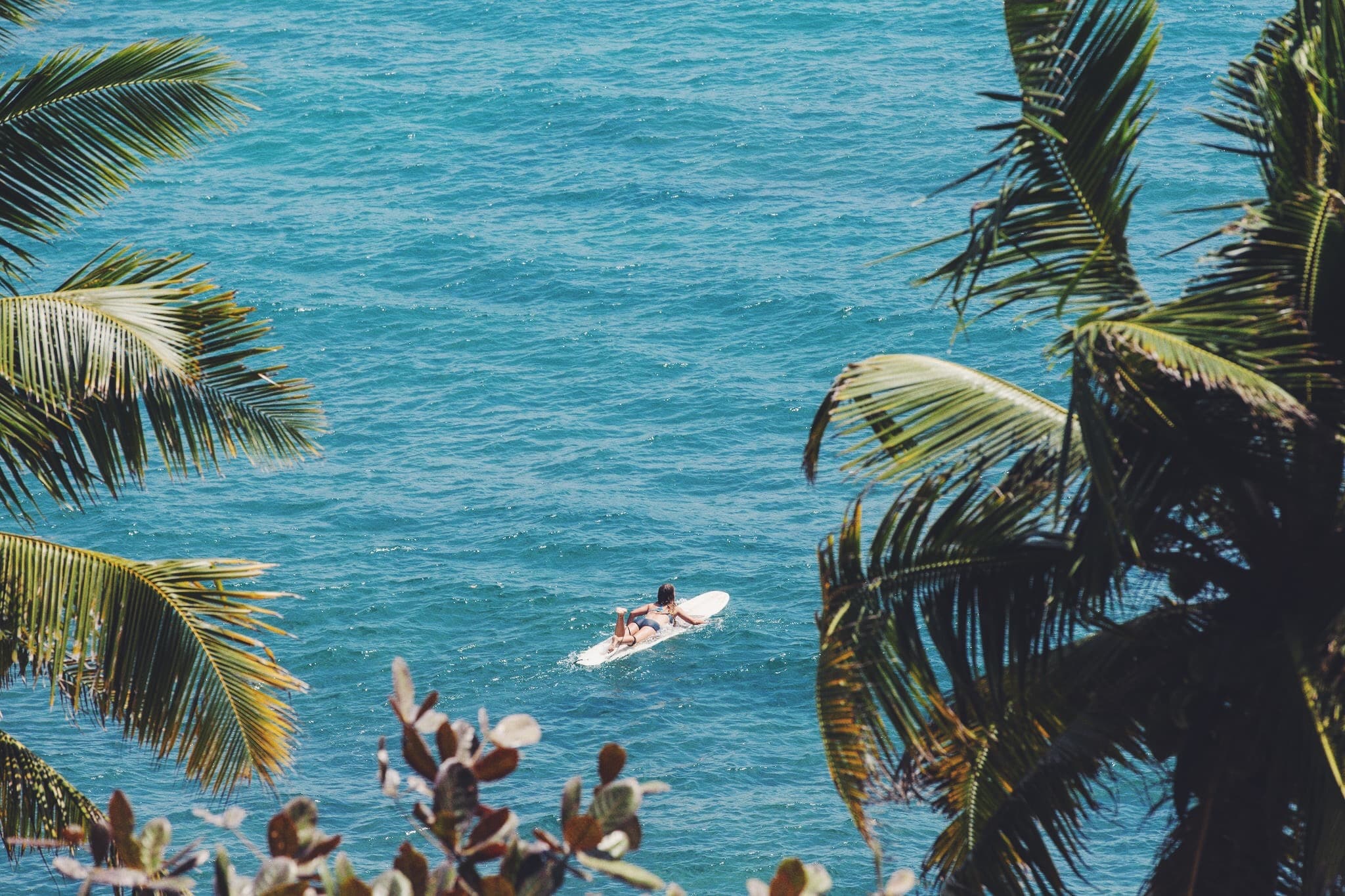 Girl surfing longboard waves in the Maldives