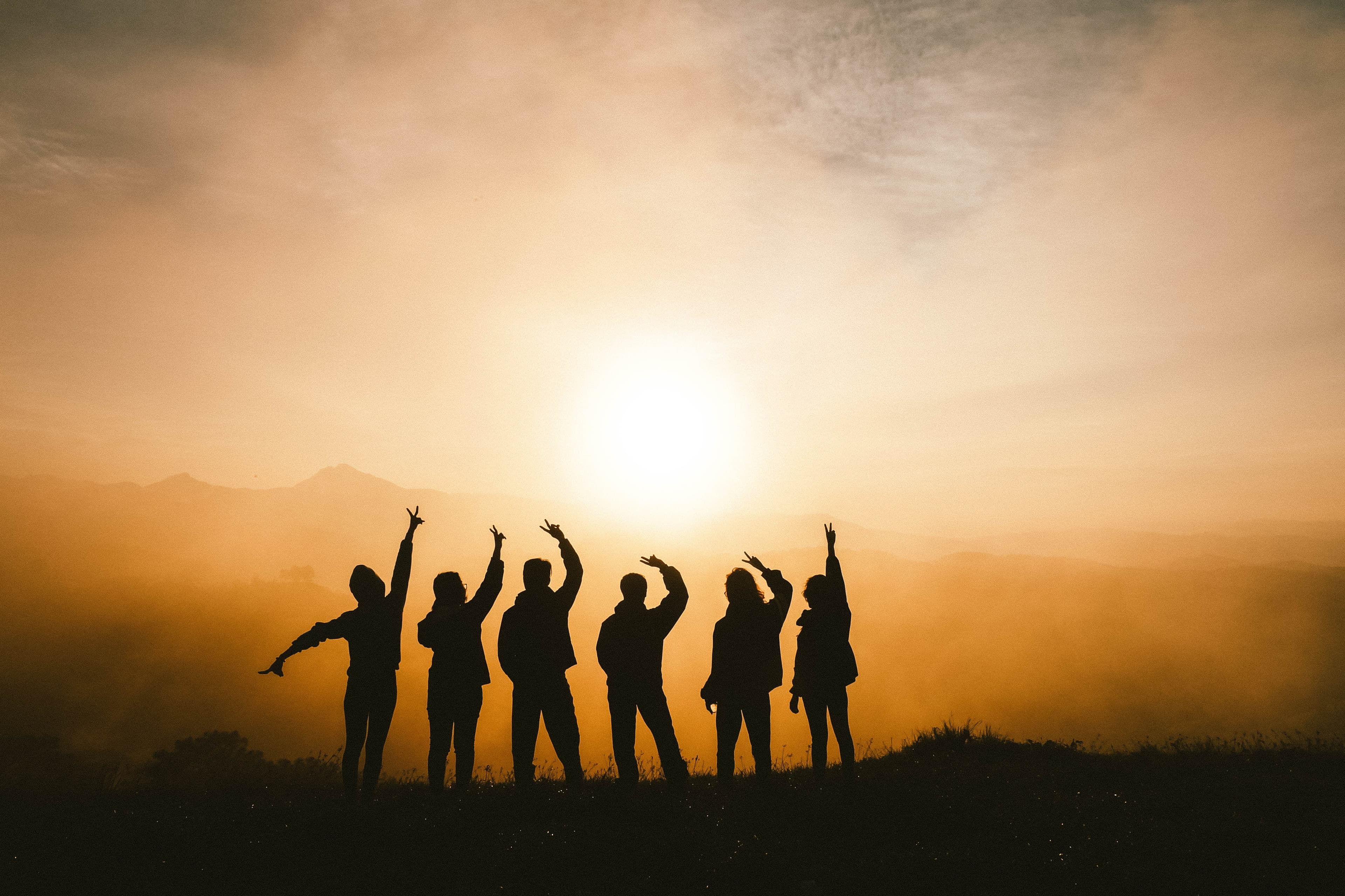 Friends in the sunset creating silhouettes