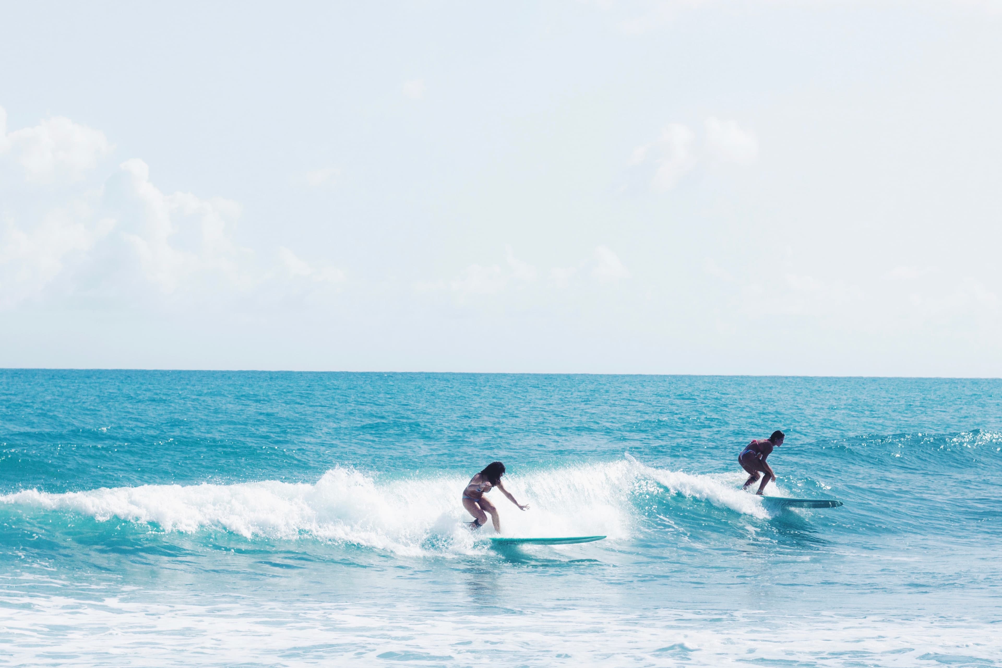 Girl surfing longboard waves in the Maldives