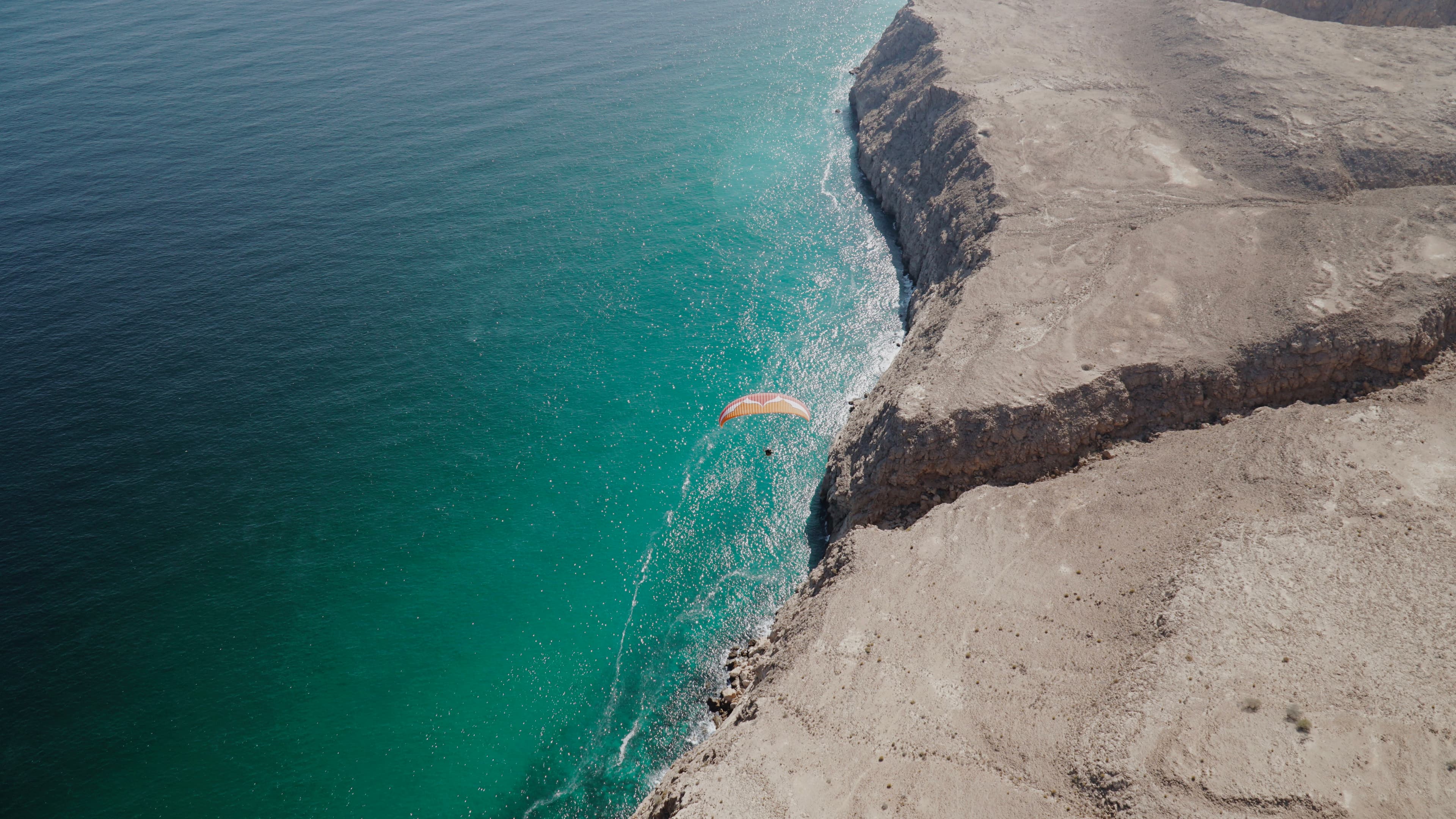 Person flying with a paramotor over the ocean