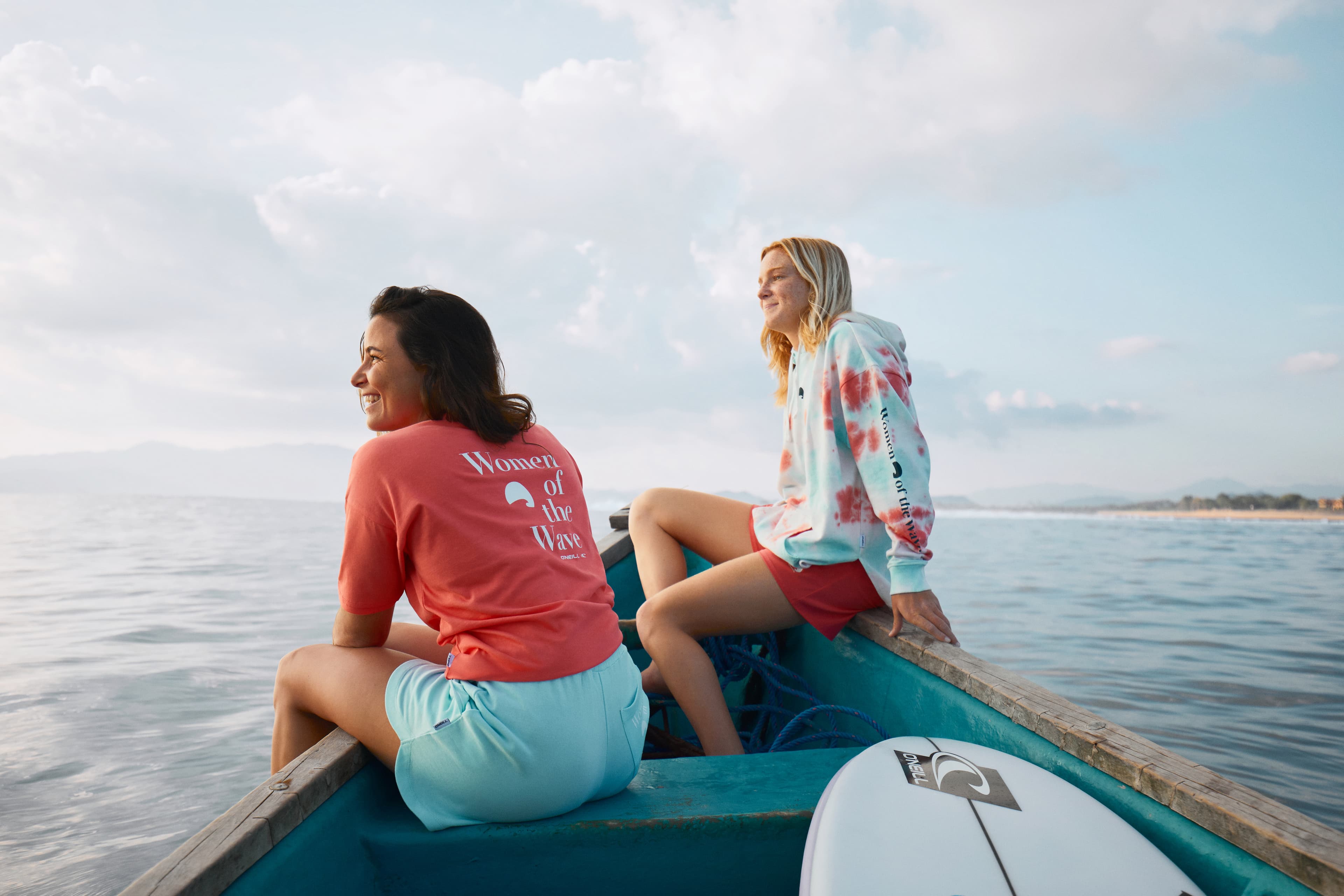 2 GIRLS IN A BOAT LOOKING OVER THE SUNSET