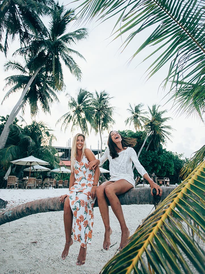 Girls smiling on a palm tree