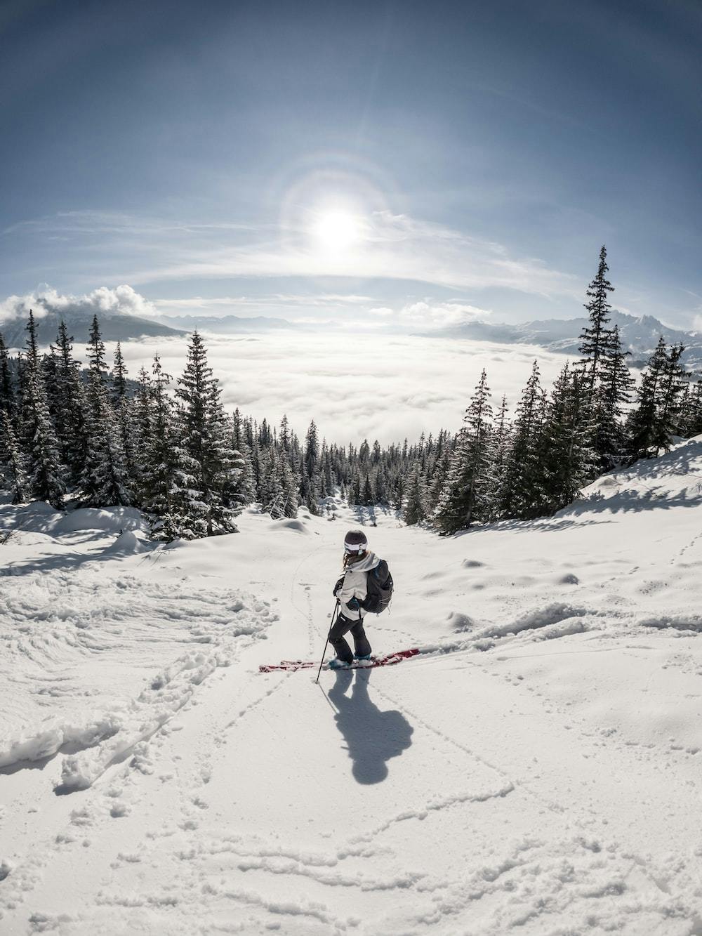 Girl skiing over the clouds with the sun shining