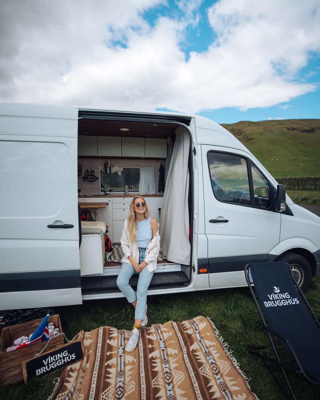 A girl sits in a van in a roadtrip in iceland.