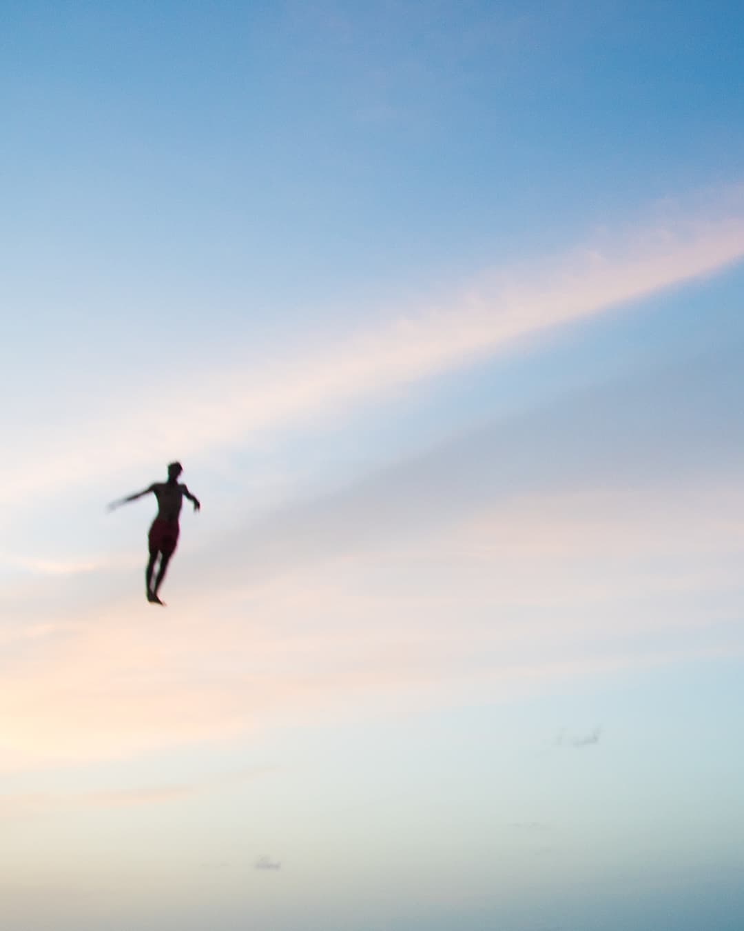 A group of friends jumping into the ocean in black and white