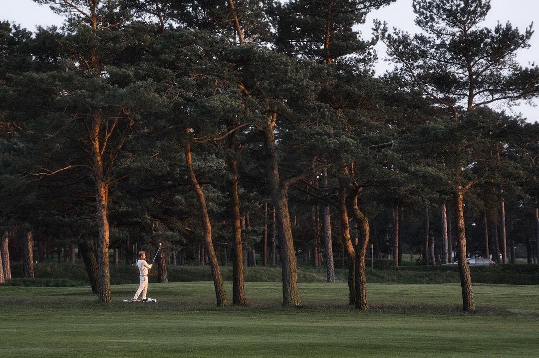 Man playing golf at sunset