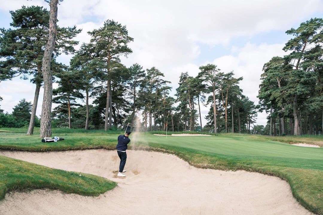 man bunker playing golf