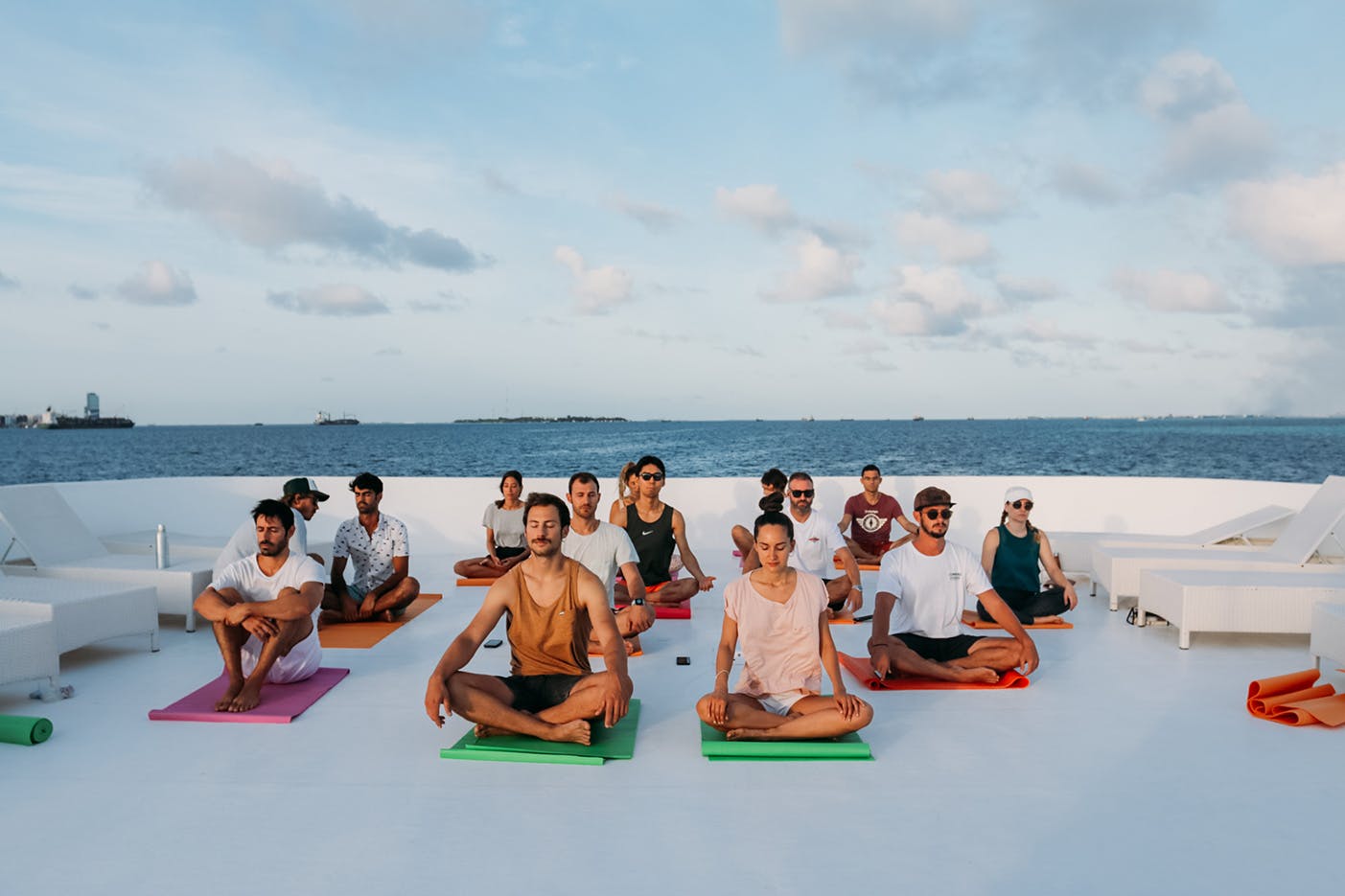 A group of friends meditates in a Yacht 