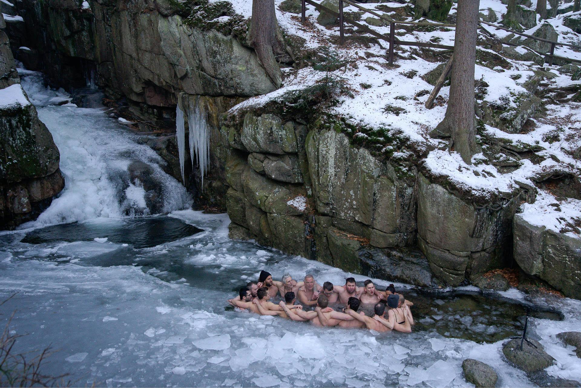 Group taking an ice bath in a frozen waterfall in Poland with Wim Hof