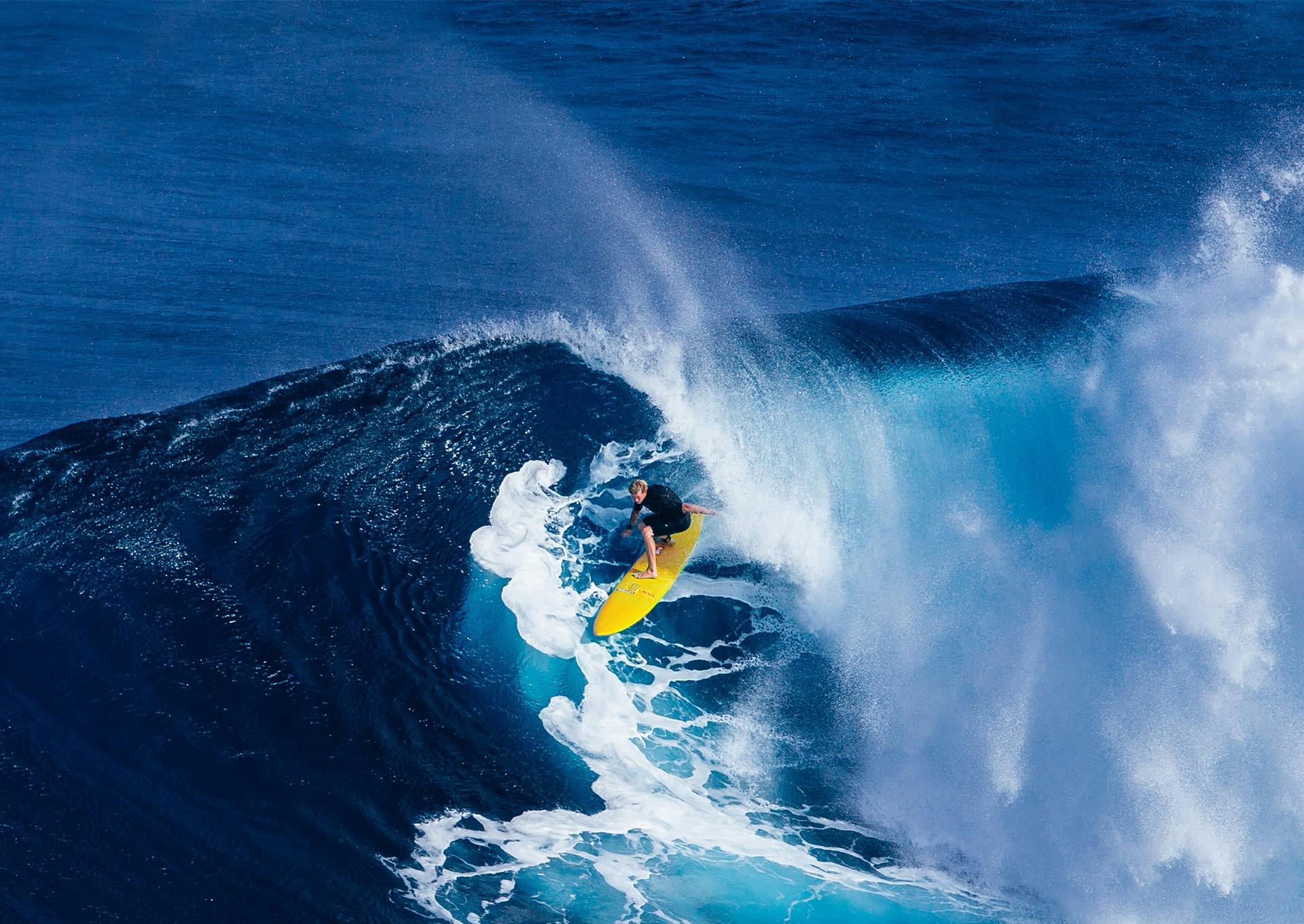 A man surfing on a yellow surfboard