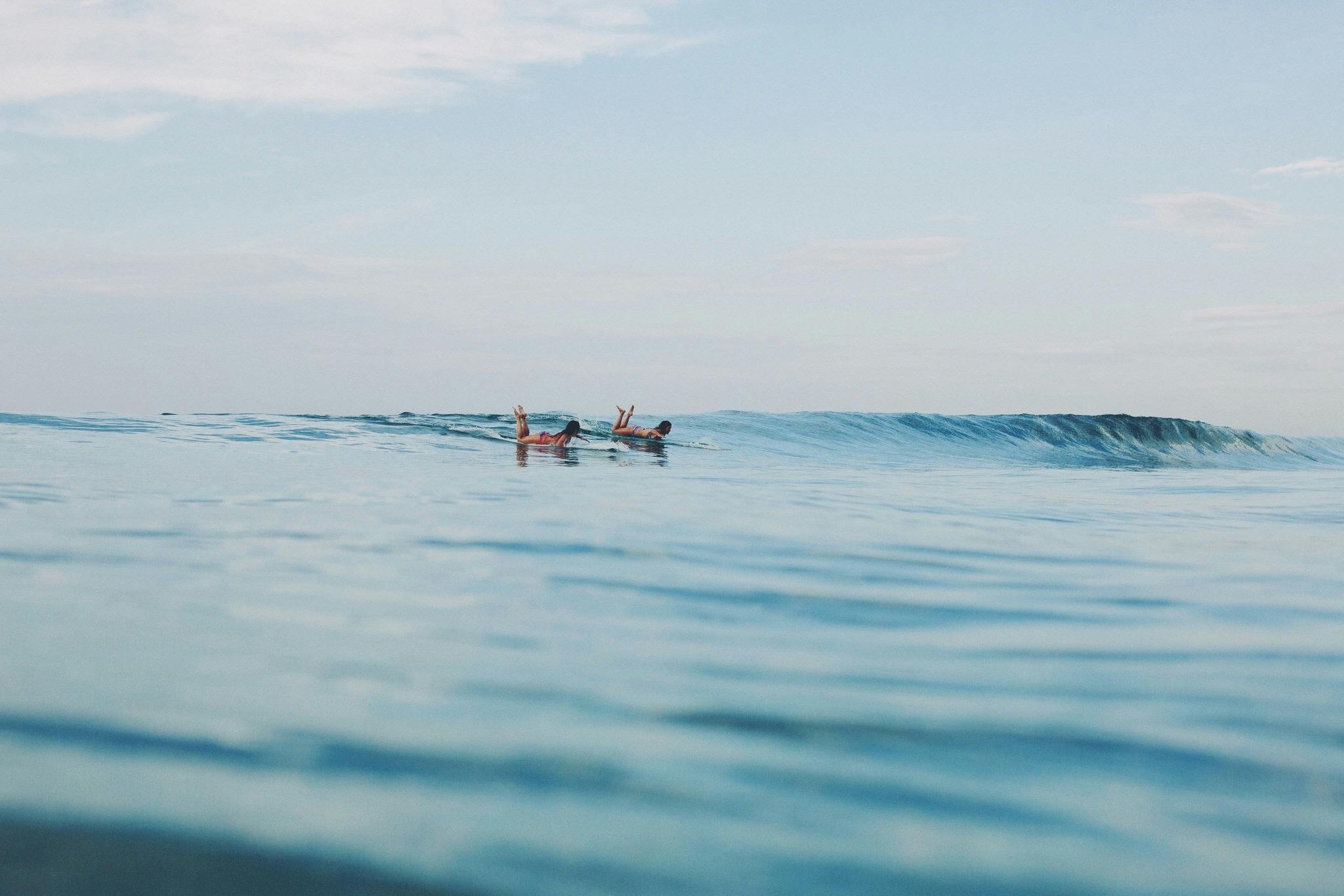 Girl surfing longboard waves in the Maldives