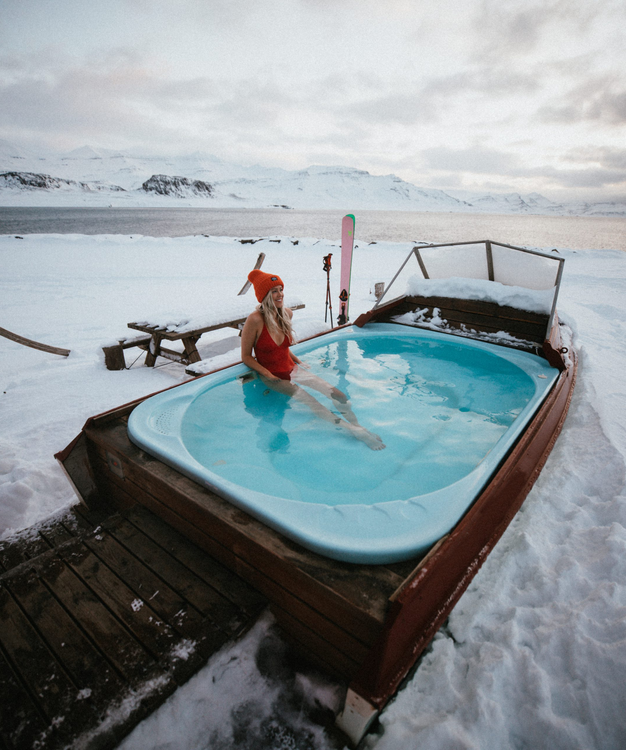 Asa in a hot tub in Iceland with her skis in the background