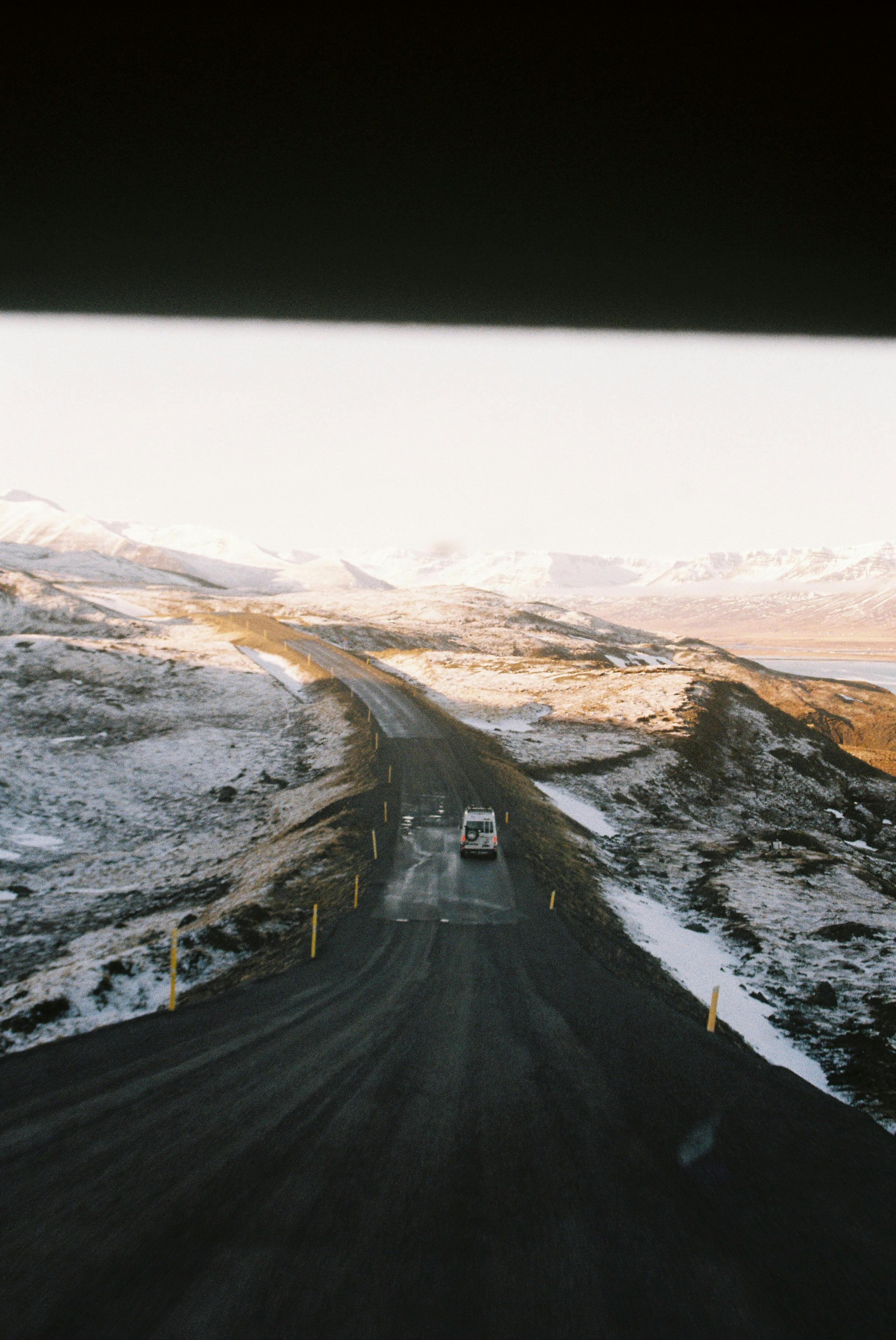 Photo taken from inside a van in iceland to other vans and snow and mountains