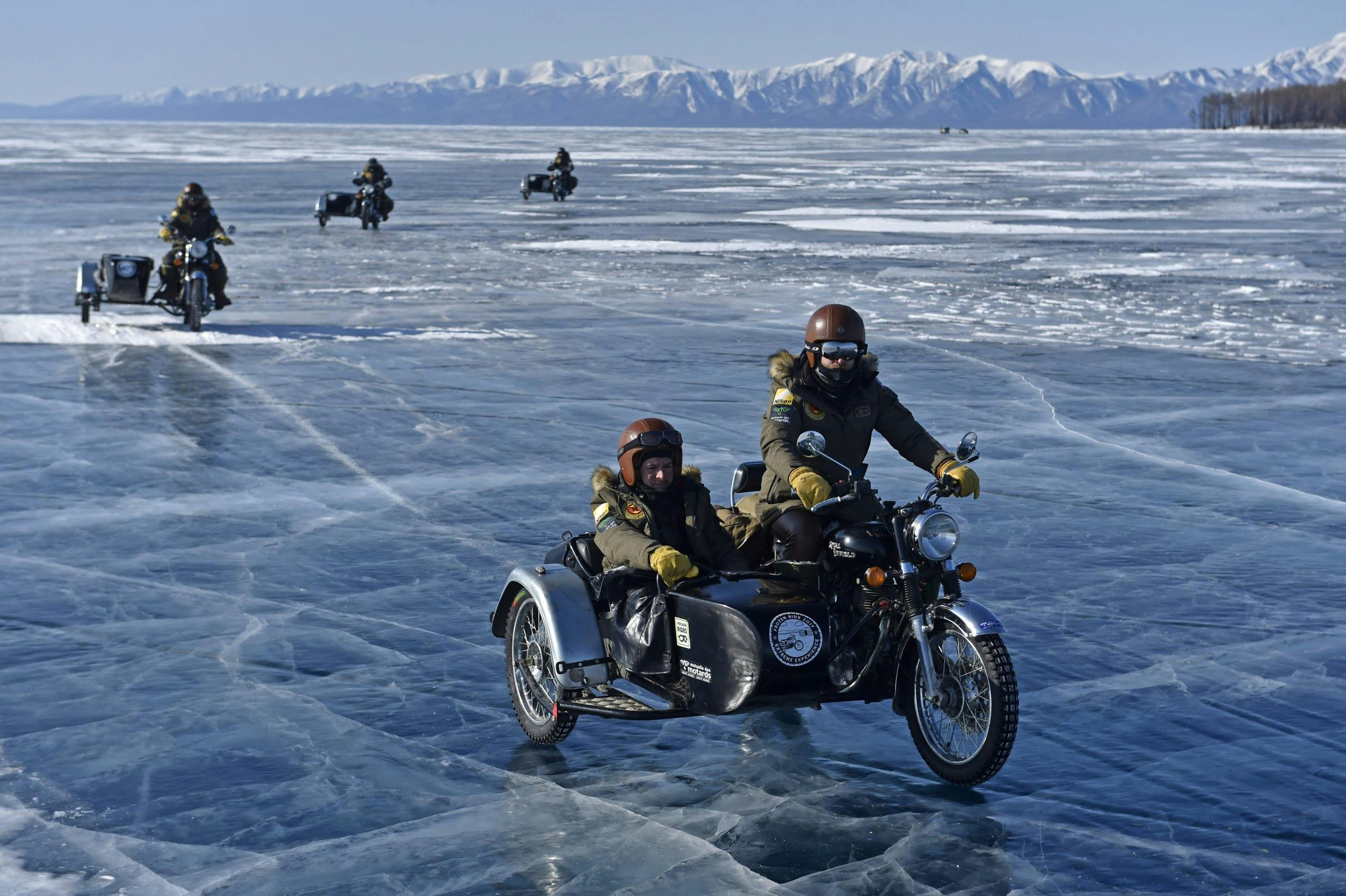 Two guys in a sidecar driving through a frozen lake in Mongolia. 