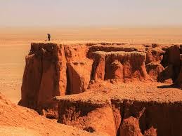A man standing in the top of the Flamming Cliffs of Gobi in Mongolia