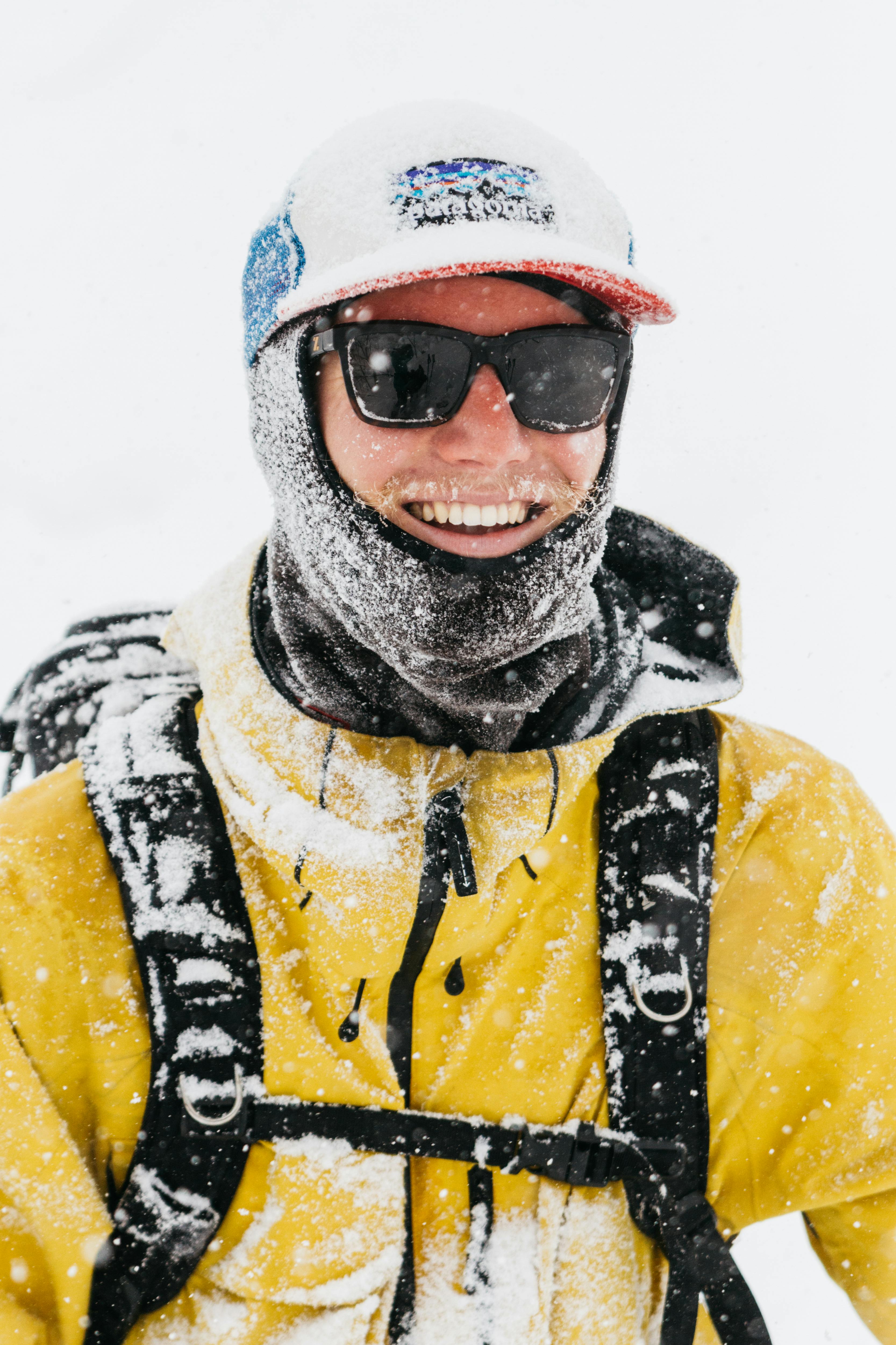 Man smiling in ski gear full in snow in Niseko