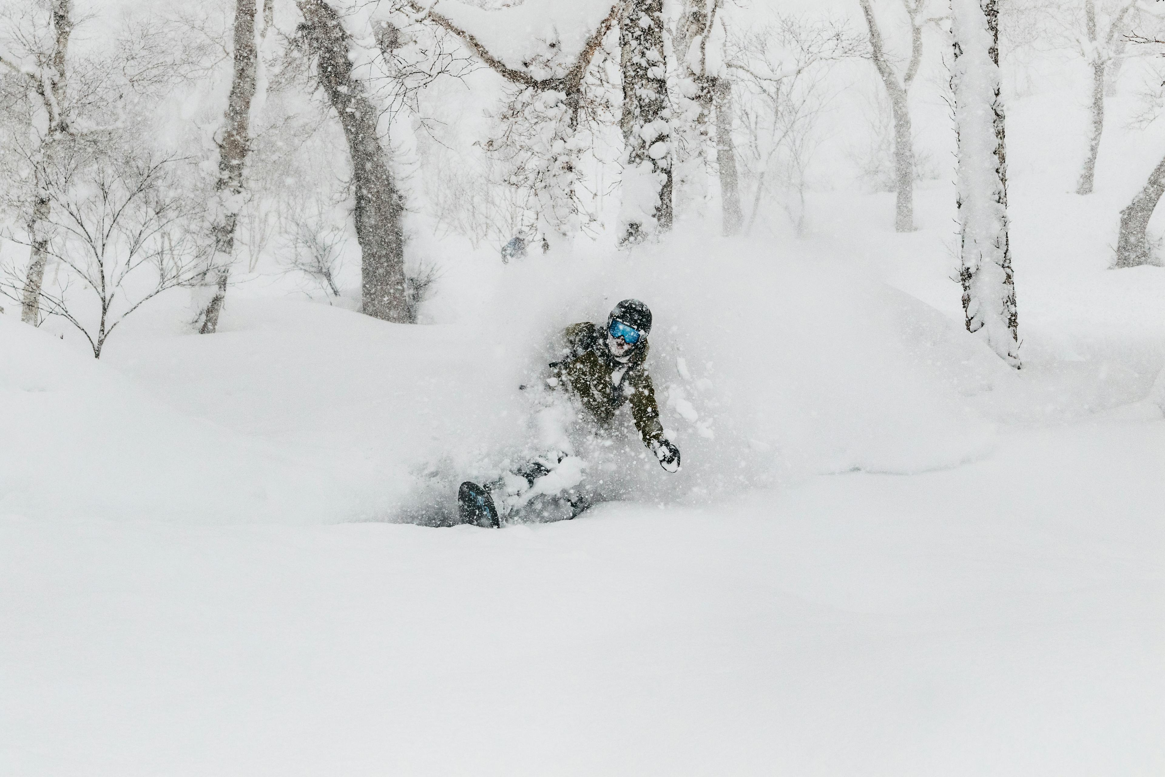 Man snowboarding in fresh powder snow in Niseko