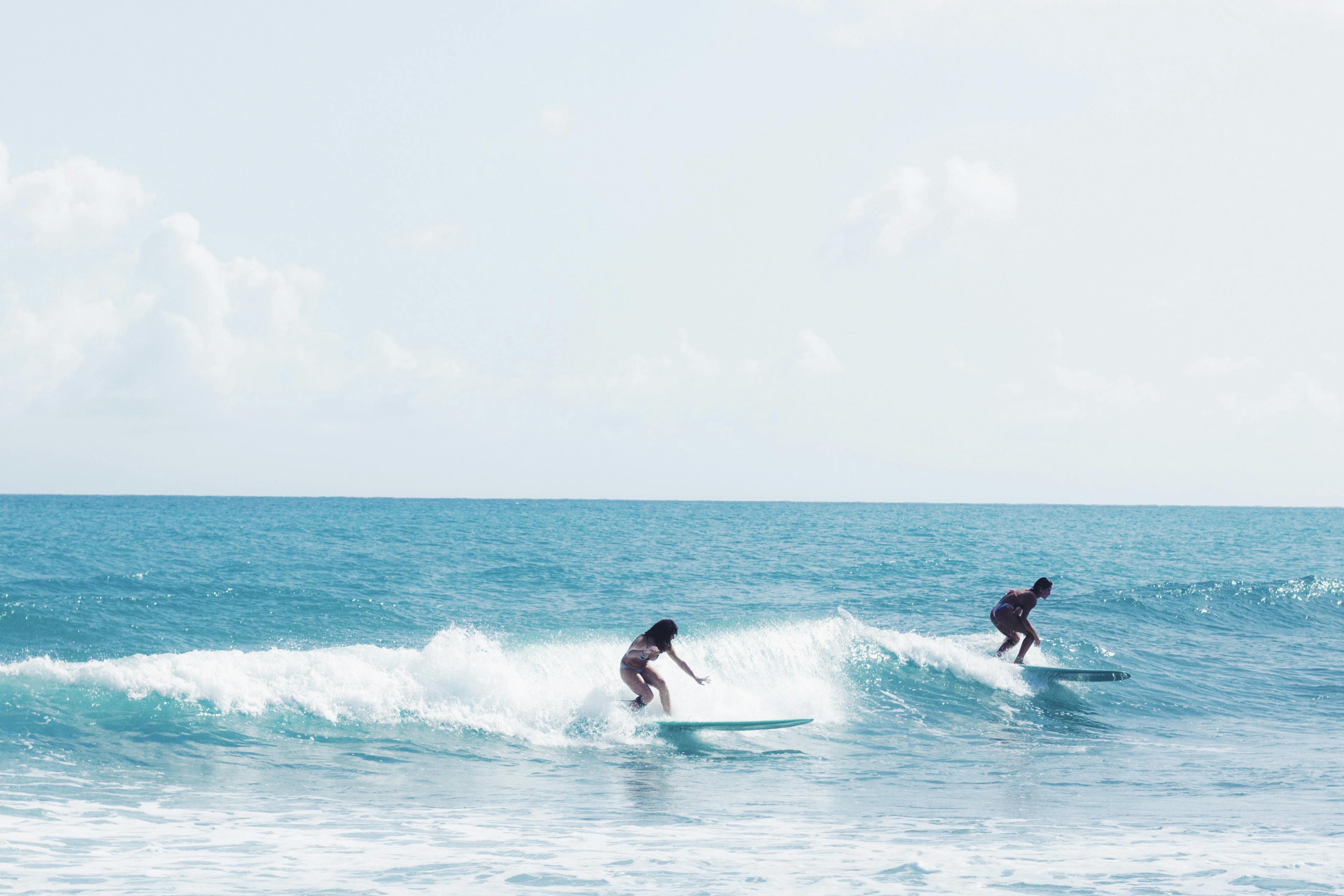 Girl surfing longboard waves in the Maldives
