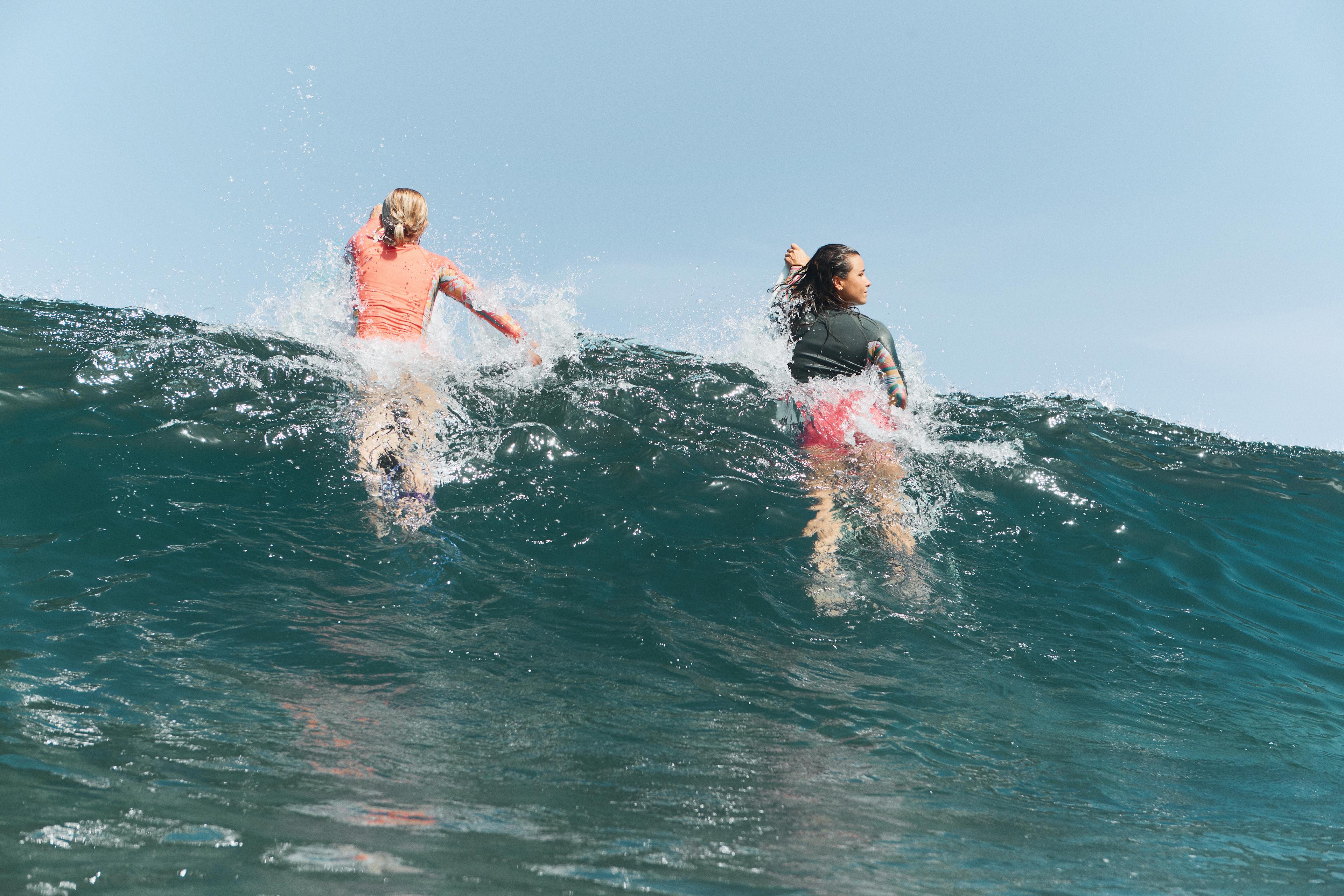 2 girls catching wave