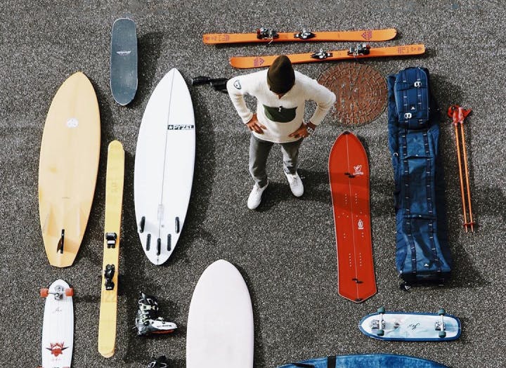 Guy with new surfboards, skateboards and ski's
