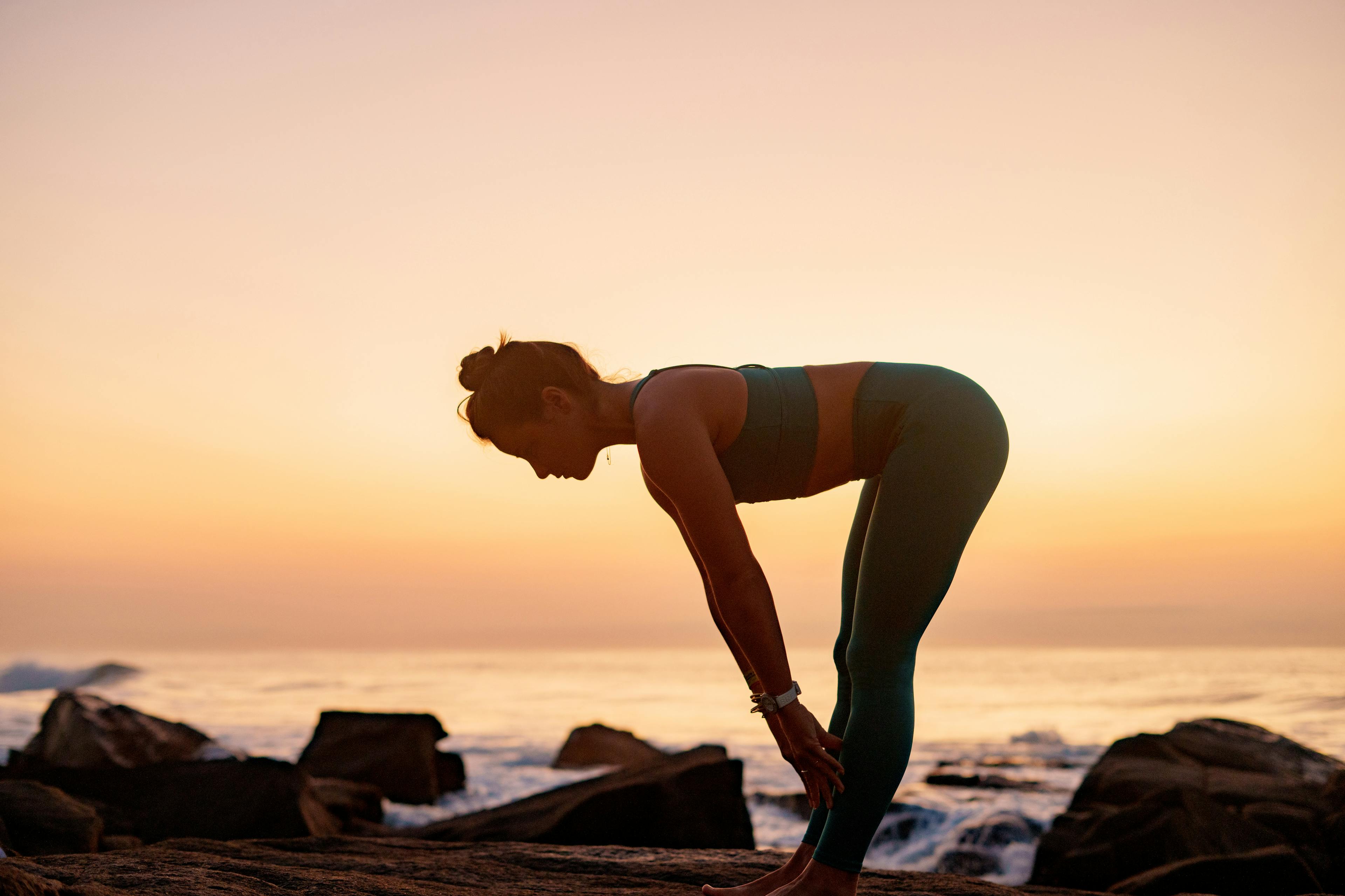 Girl doing yoga at sunset